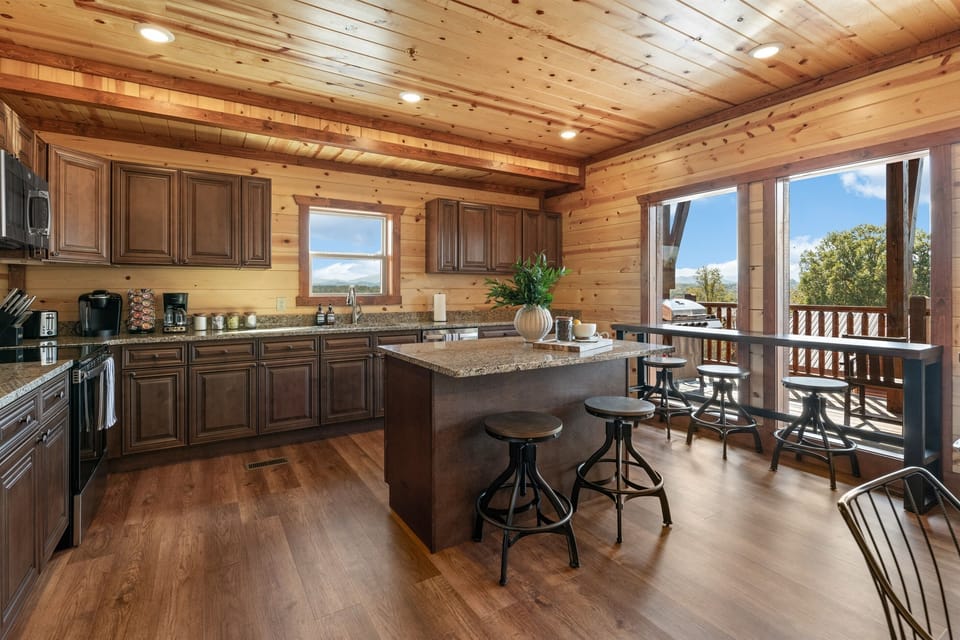 Fully equipped chef’s kitchen with granite countertops and bar seating.