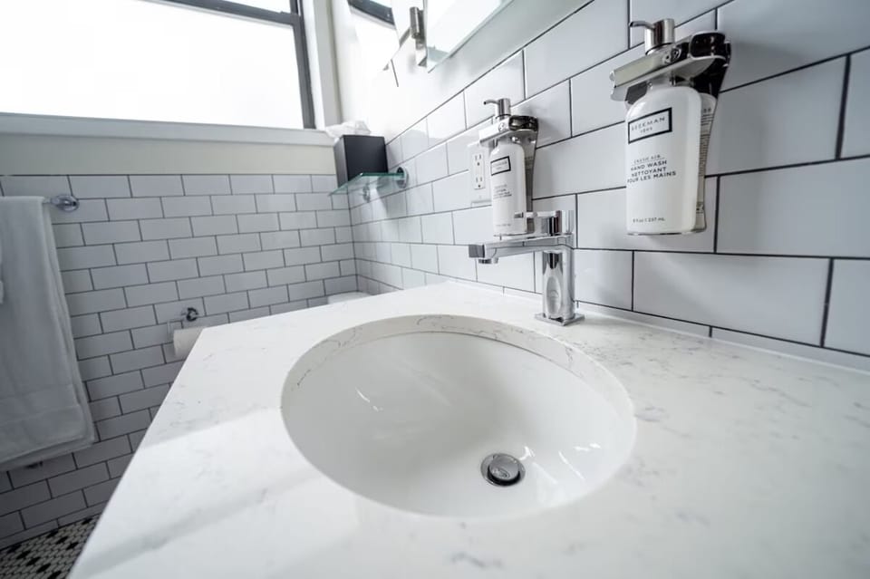 Freshen up with bright marble vanity and premium soap dispensers.