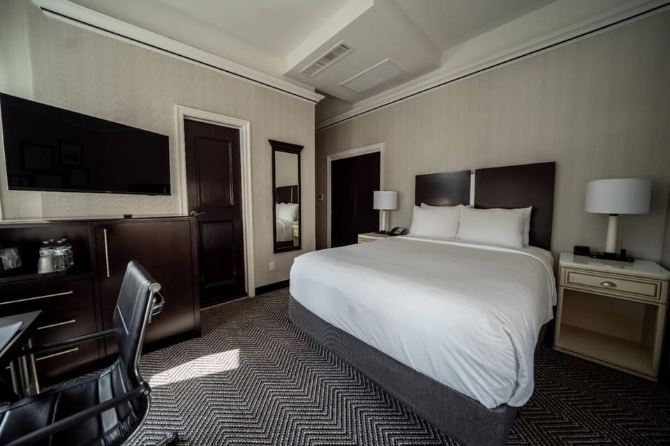 Unwind in a serene room with TV and plush bedding.