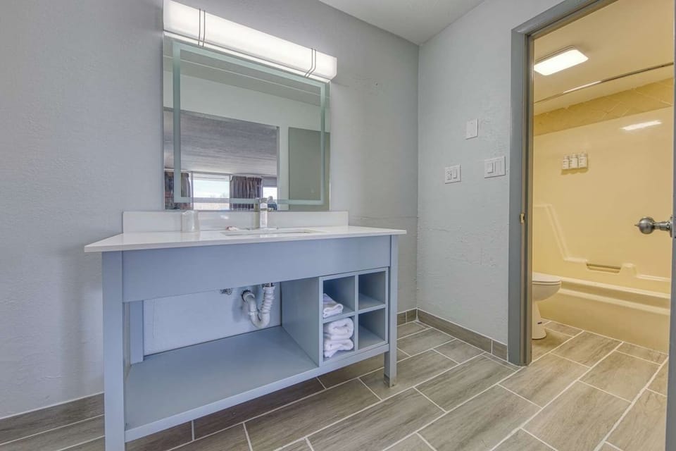 Refresh effortlessly with bright vanity lighting and tidy towel storage.