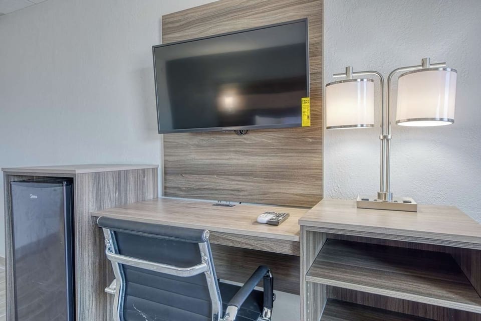 Settle in with a comfy desk, big TV, and mini fridge.
