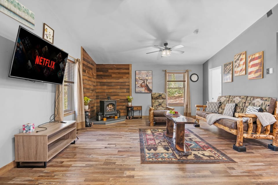 The rustic wood paneling and log-frame sofa set a cozy, nature-inspired tone, perfect for unplugging from the daily grind.