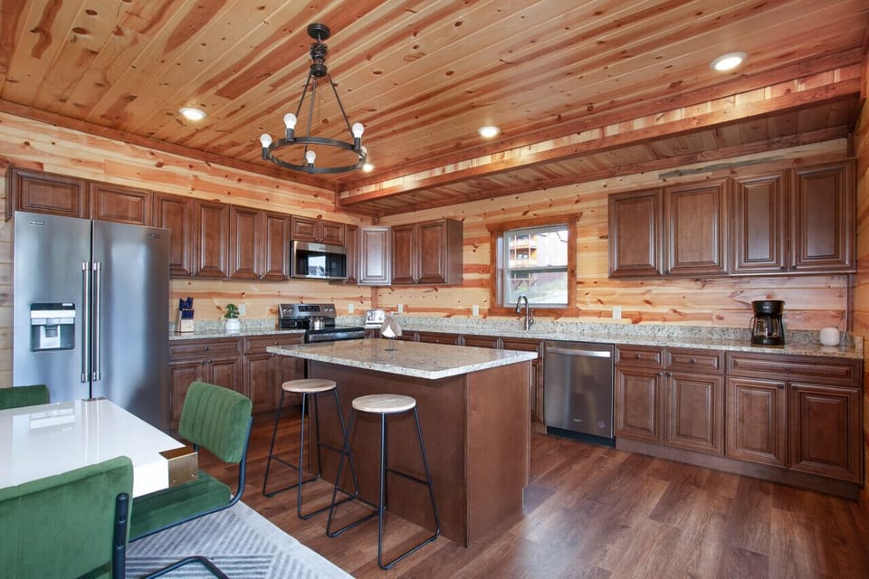 Spacious kitchen with island seating, stainless steel appliances, and cabin elegance.