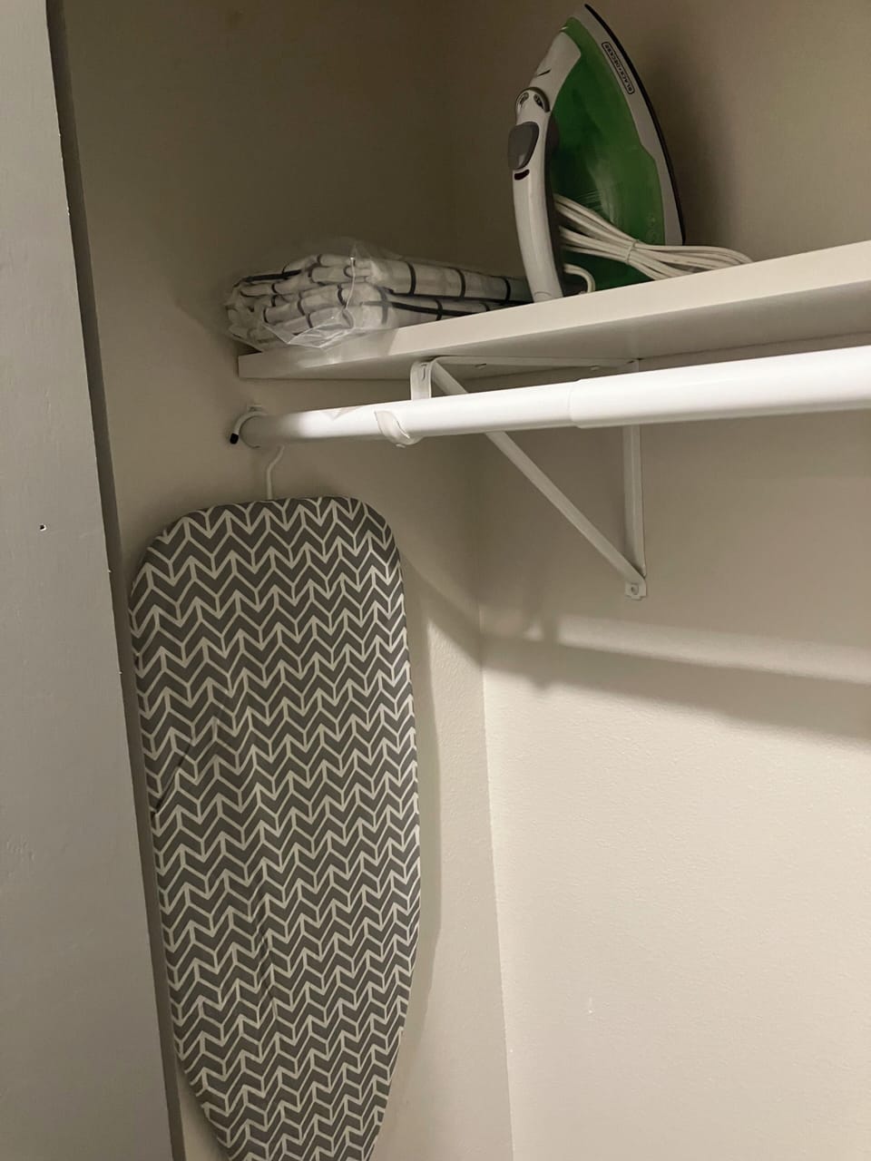 Iron and iron board in closet for use.