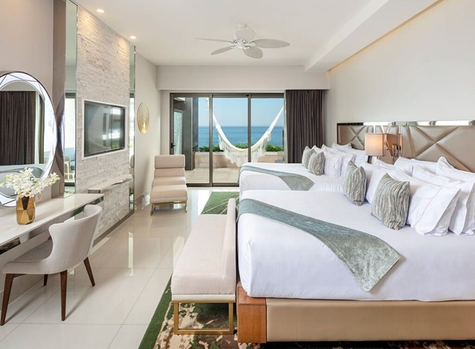 Junior suite showing 2 queen beds, desk,
chair and lounge chair.