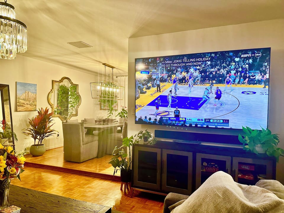 Huge TV beside dining area.