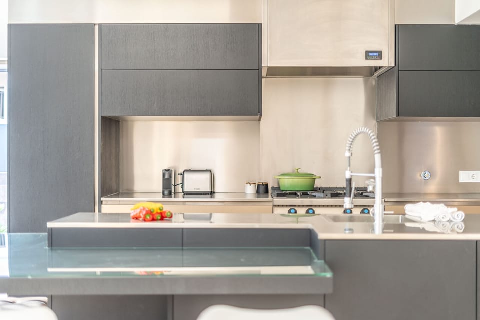 Modern kitchen with stainless steel countertops and green cookware — Villa Geranios, holiday villa in Belverde