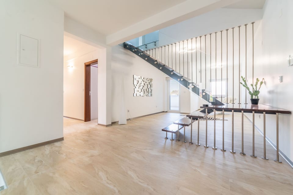 Modern open-plan living space with floating staircase — Villa Geranios, luxury holiday villa in Belverde