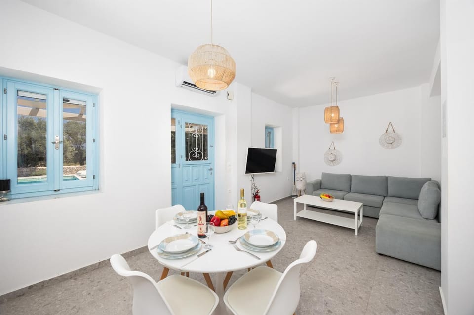 Open-plan living room with sofa, dining area, kitchen, A/C, WiFi internet, and satellite TV
