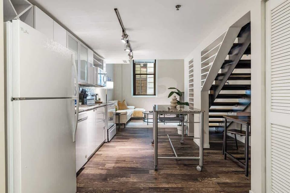 Modern loft with a sleek kitchen, open layout, and stylish staircase design.