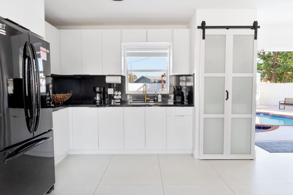 Modern kitchen in Miami Gardens with white cabinetry & gold accents.