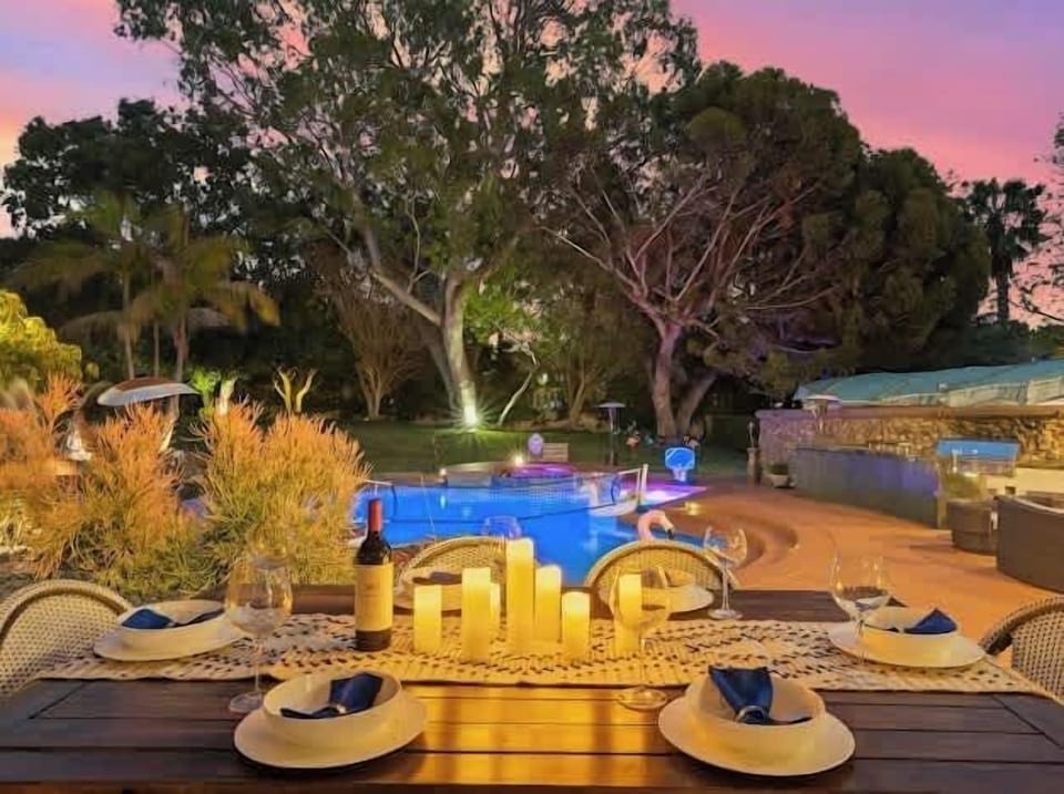 Indulge in a romantic dinner under the stars, with a beautifully set table and breathtaking views of the pool and lush landscape. The perfect setting for a memorable evening.
