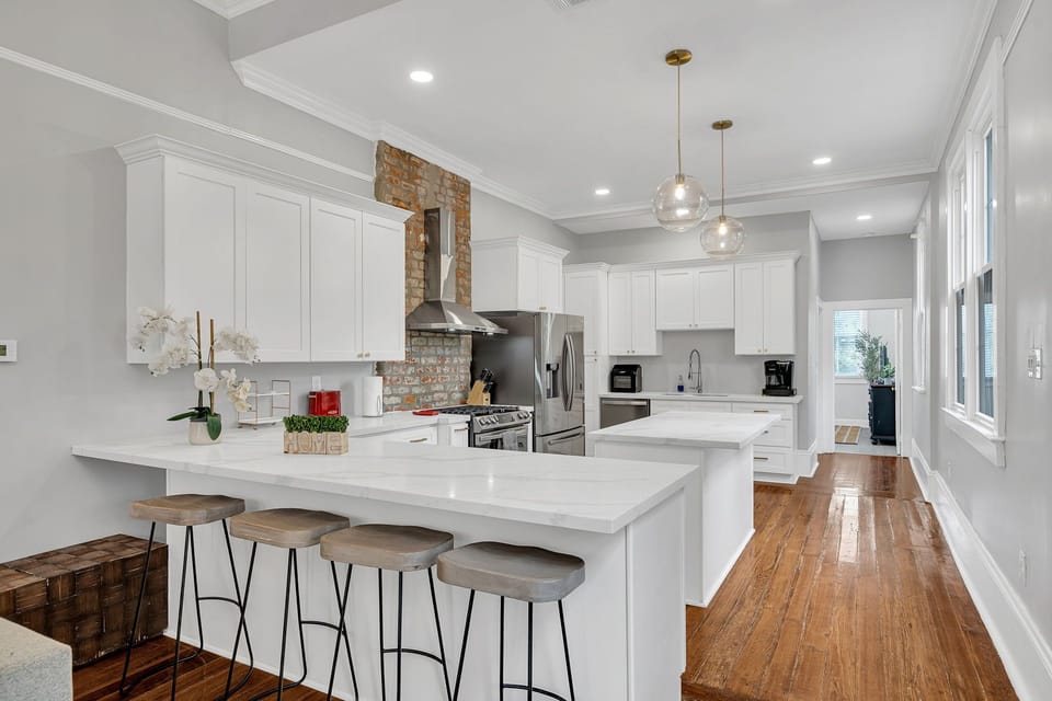 Bright and open living area with a stylish sectional and sleek kitchen, perfect for relaxing and entertaining.