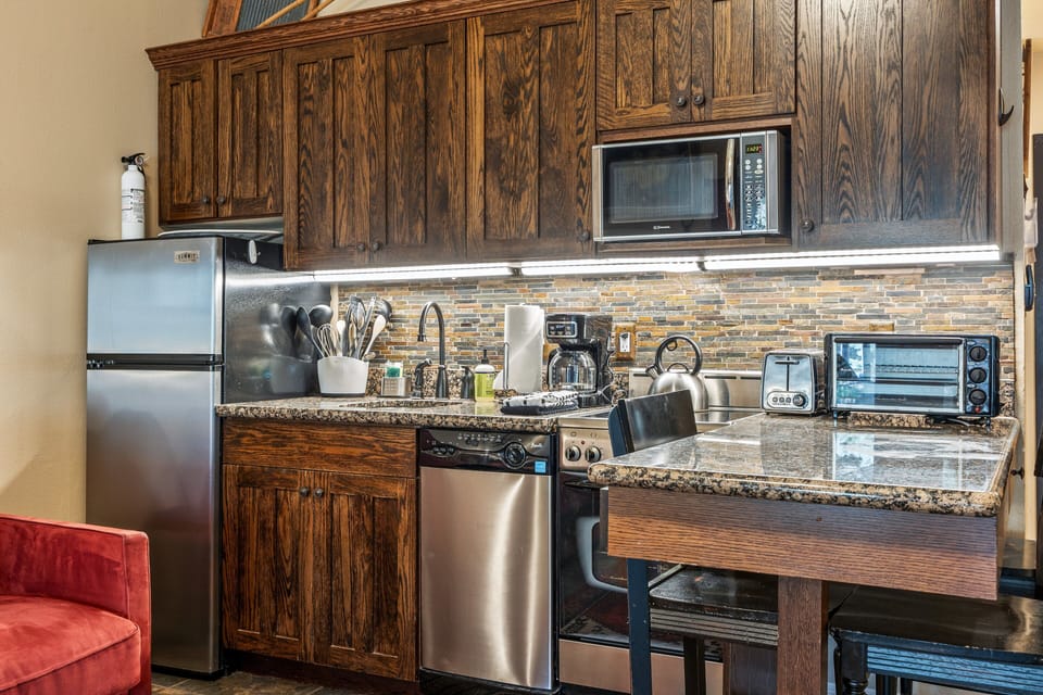 Well-equipped kitchen with stainless steel appliances, granite countertops, and everything needed for meals.