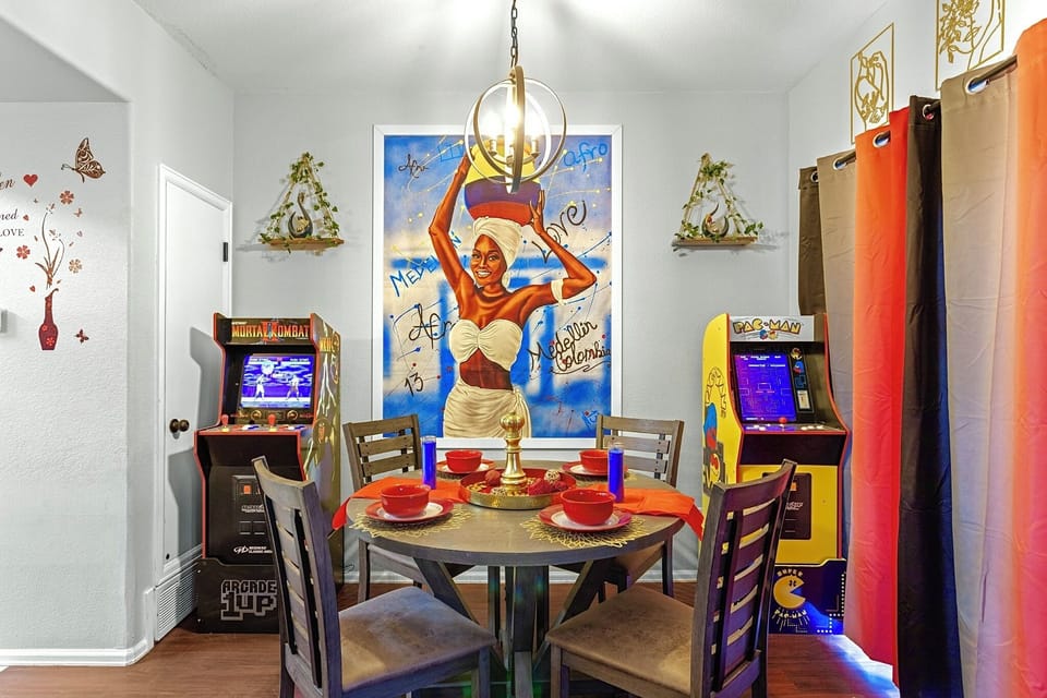 Fun and vibrant dining area with a retro arcade game and colorful decor. Perfect for family meals and game nights.