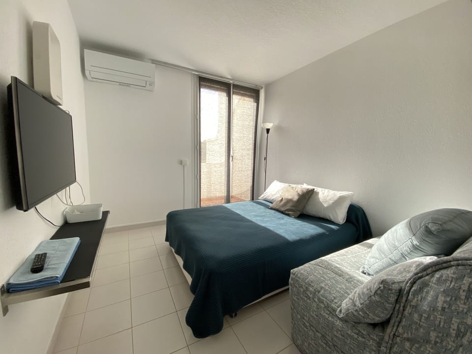 Room equipped with a double bed, a double sofa bed, a TV and a window that brings brightness