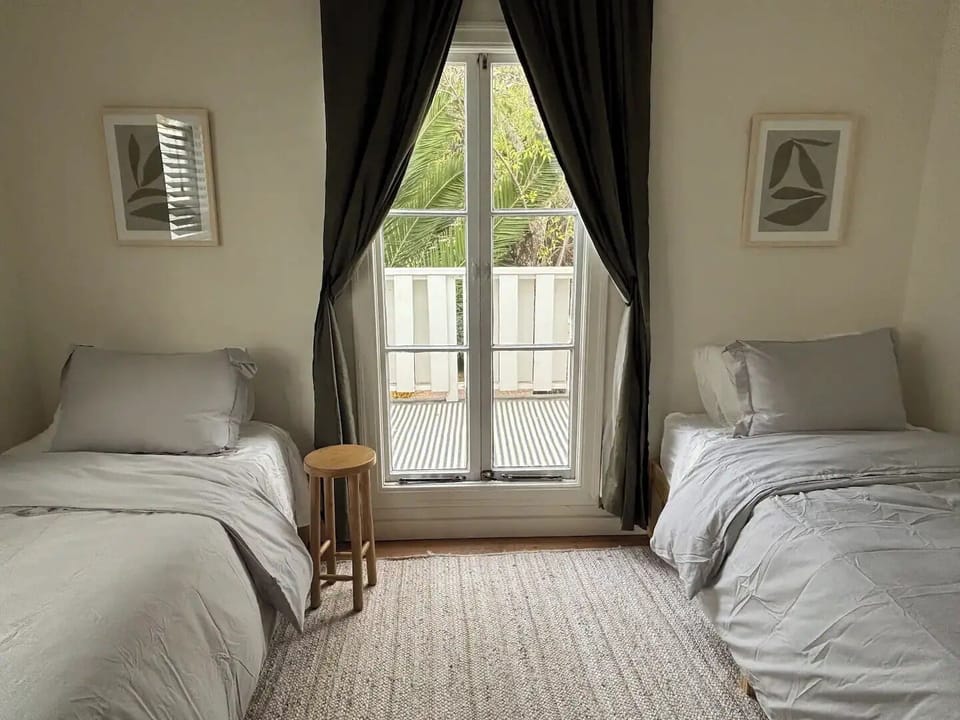 secondary bedroom with two twins, work desk and walkout deck.