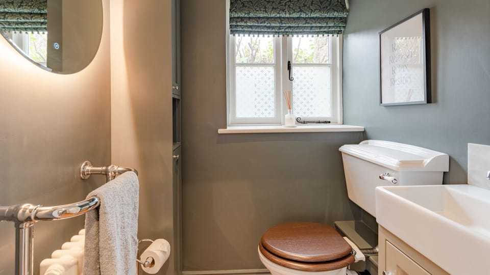 The ground floor cloakroom has a touch of drama in deep grey