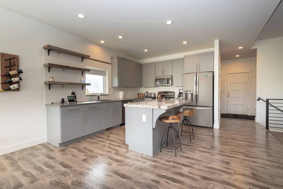The gourmet kitchen features a kitchen island and is equipped with stainless steel appliances, including a microwave, stove, and spacious refrigerator.