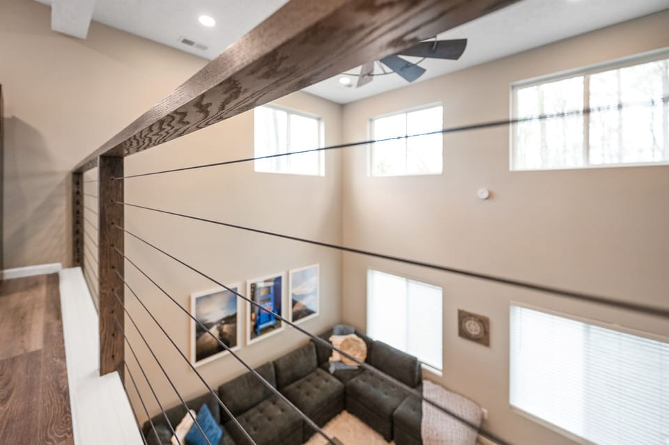 Look down from the loft into the spacious living room below—an open, airy layout.