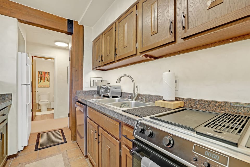 Galley kitchen with refrigerator, freezer, washer/dryer, and main floor bathroom