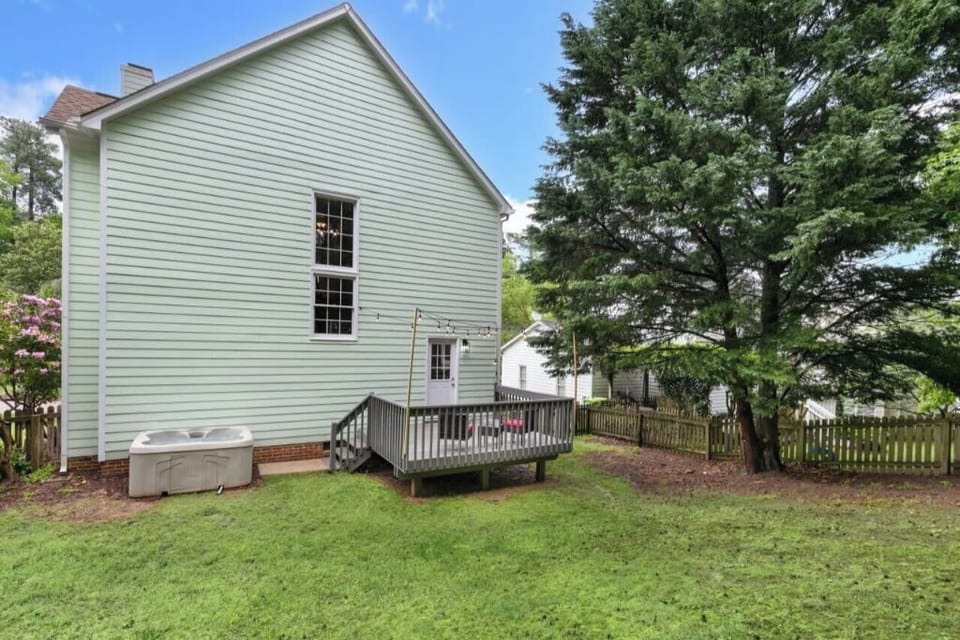 With hot tub, deck, and lush greenery.