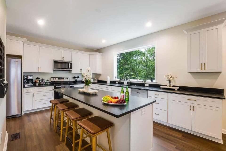 Sleek kitchen w/ large island, modern finishes & wide windows for natural light