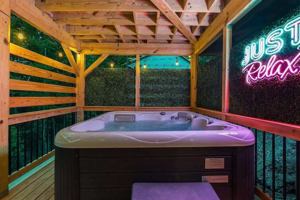 Private hot tub corner w/ warm wood beams & neon glow