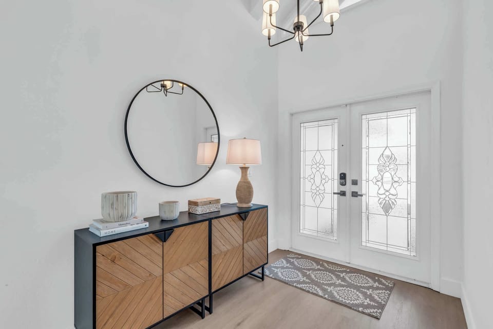 The main foyer welcomes guests into the home with its natural light and credenza 
