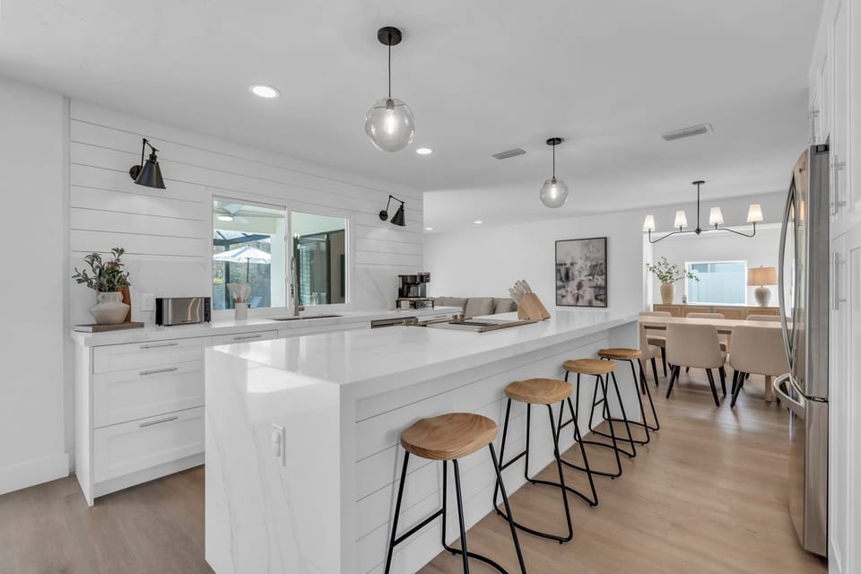 The kitchen of the home has a farm and beach house vibe and has a large center island with seating for 4 