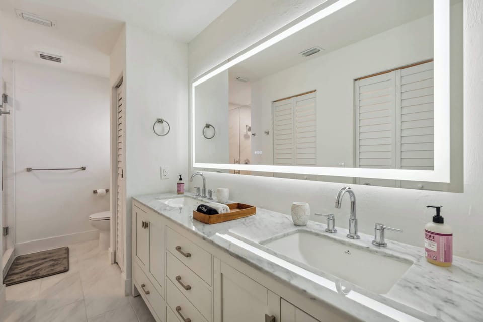 The main bathroom: a view from the vanity down to the toilet and the glass enclosed shower (on the left) 