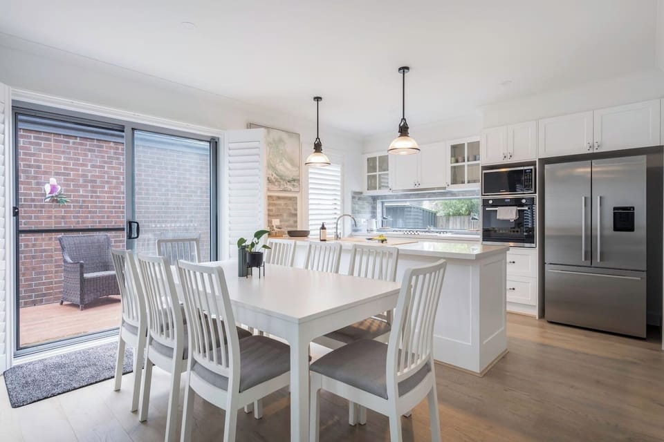 The open-plan dining area offers a welcoming space to gather, perfect for enjoying meals. With natural light flowing in, it’s an inviting spot for relaxed dining or lively conversation.