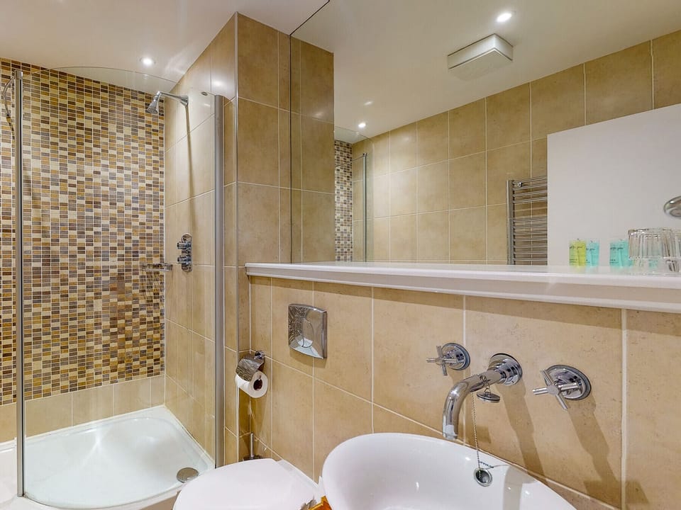 Castlemartyr Holiday Lodges, East Cork, County Cork, Ireland. Pet friendly holiday home. Contemporary tiled bathroom. Stylish tiled shower. Large mirror. Modern sink.