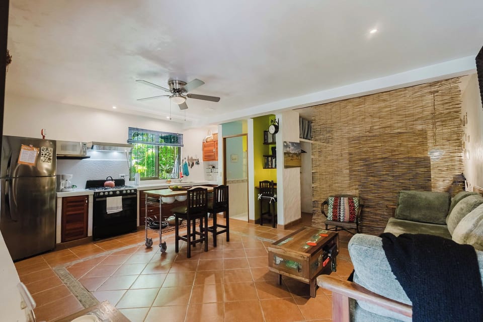 Bright open living area with full kitchen, dining space, and cozy seating