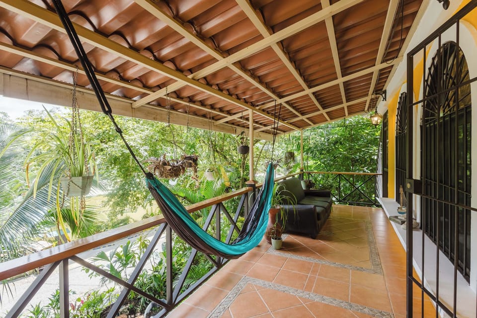 Relax on the lush covered veranda with hammock and tropical views