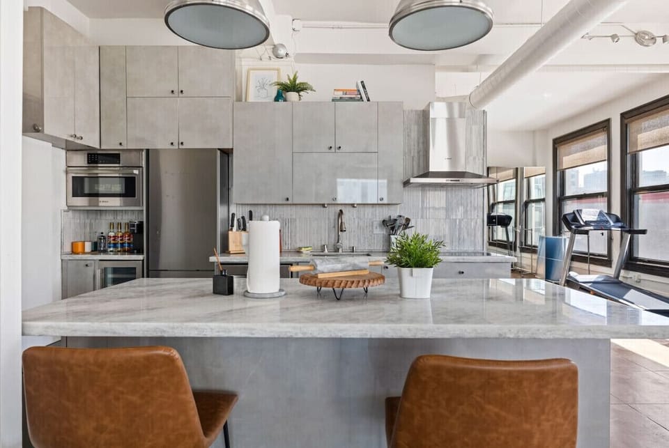 Fully equipped modern kitchen with a spacious island, perfect for cooking and dining. Enjoy sleek design and functionality in your stay.