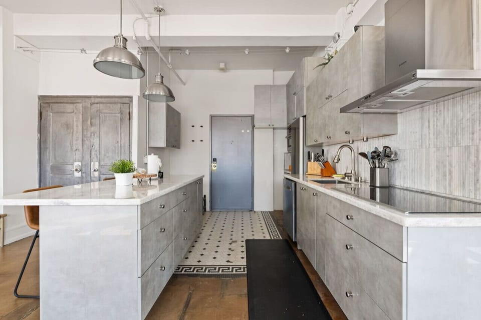 Clean and Spacious Kitchen with Sleek Countertops and Additional Seating
