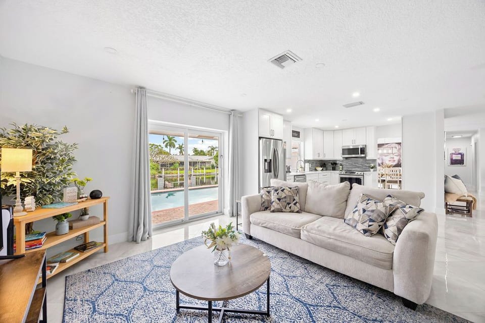 Living Room: Bright and airy space with pool views, perfect for relaxation and fun gatherings!