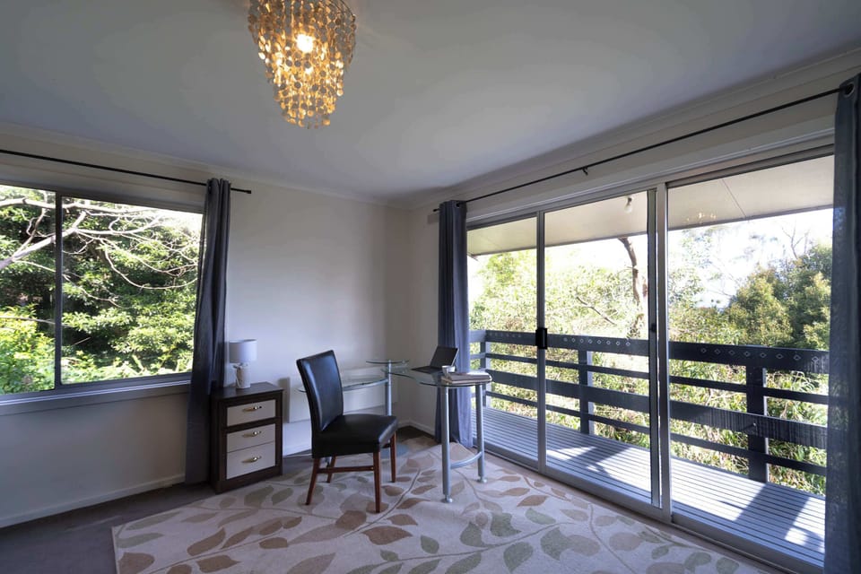 Modern workspace in bedroom, overlooking a serene balcony
