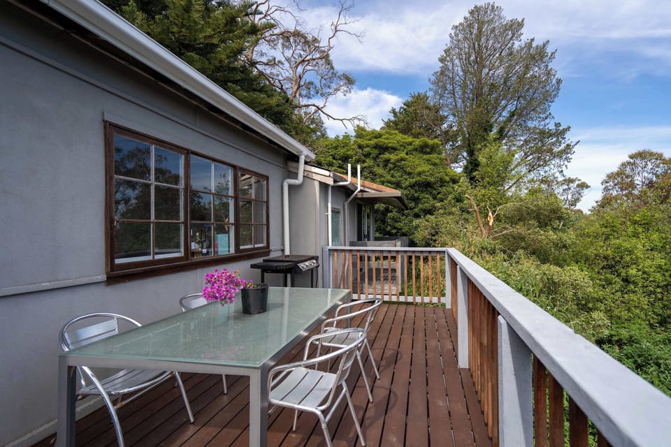Spacious wooden deck with outdoor dining furniture
