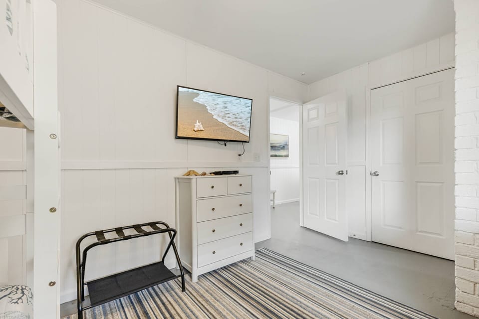 Bedroom #5 features a twin bunk bed, a flat-screen TV, drawer storage, and a dedicated workspace. Ground floor