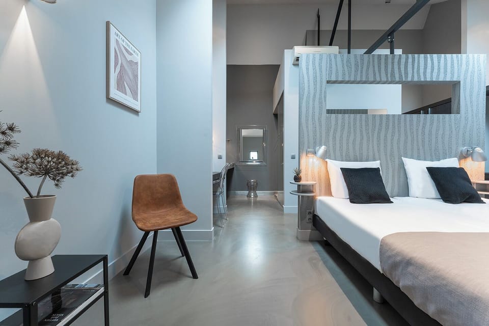  A view of the same bedroom from another angle, showcasing the cohesive design that blends sleeping and lounging spaces with understated elegance.