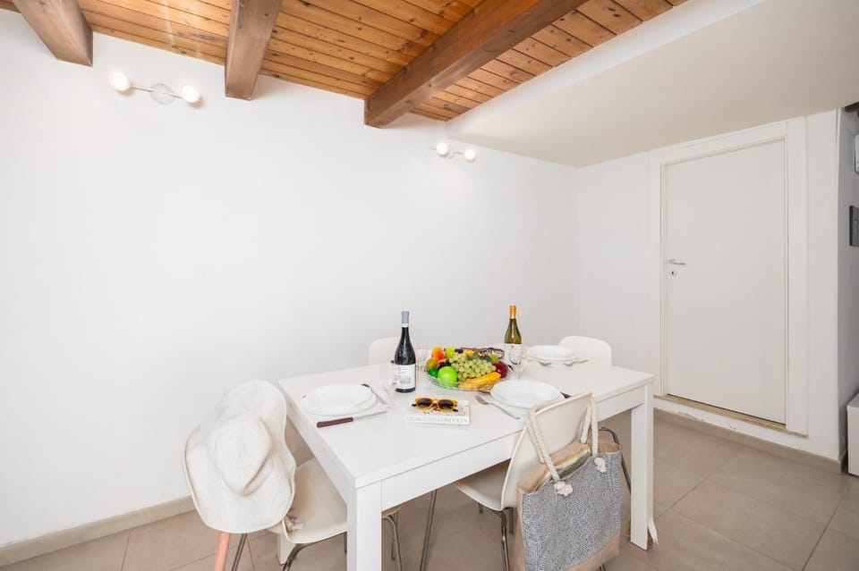 Open-plan living room with sofa, dining area, kitchen, A/C, WiFi internet, and satellite TV
