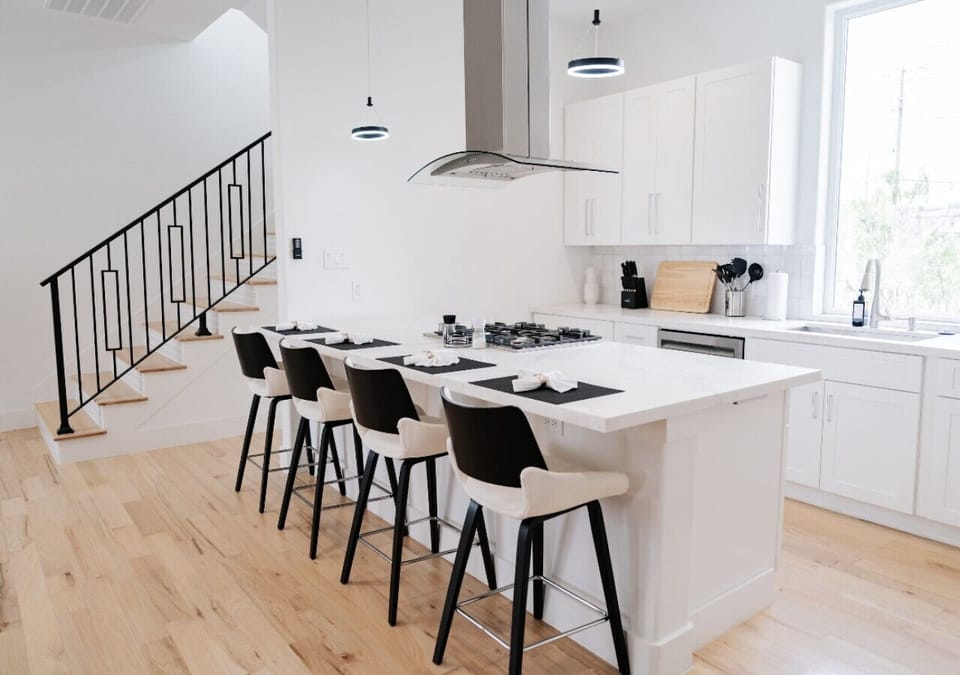 Stylish open kitchen with a breakfast bar and four high-top chairs, perfect for casual dining and entertaining.