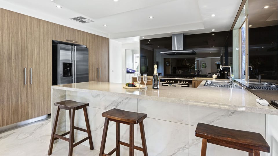 Large well equipped kitchen with breakfast bar and three stools