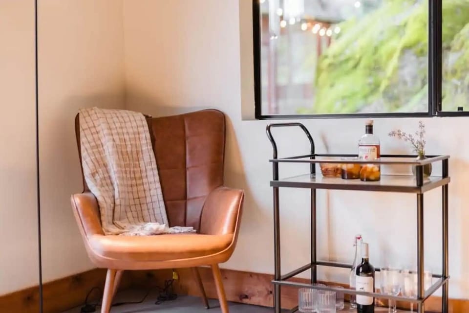 This cozy corner of the living room is designed for relaxation and enjoying a quiet moment to unwind with a good book or a warm drink. The large window allows natural light to flood in, creating a bright and airy atmosphere.