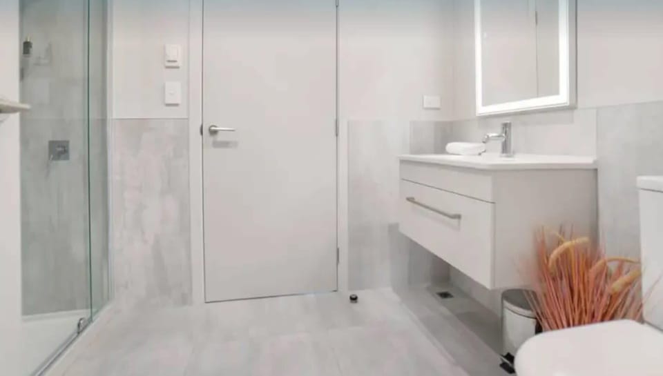 Modern bathroom with walk-in shower and LED mirror