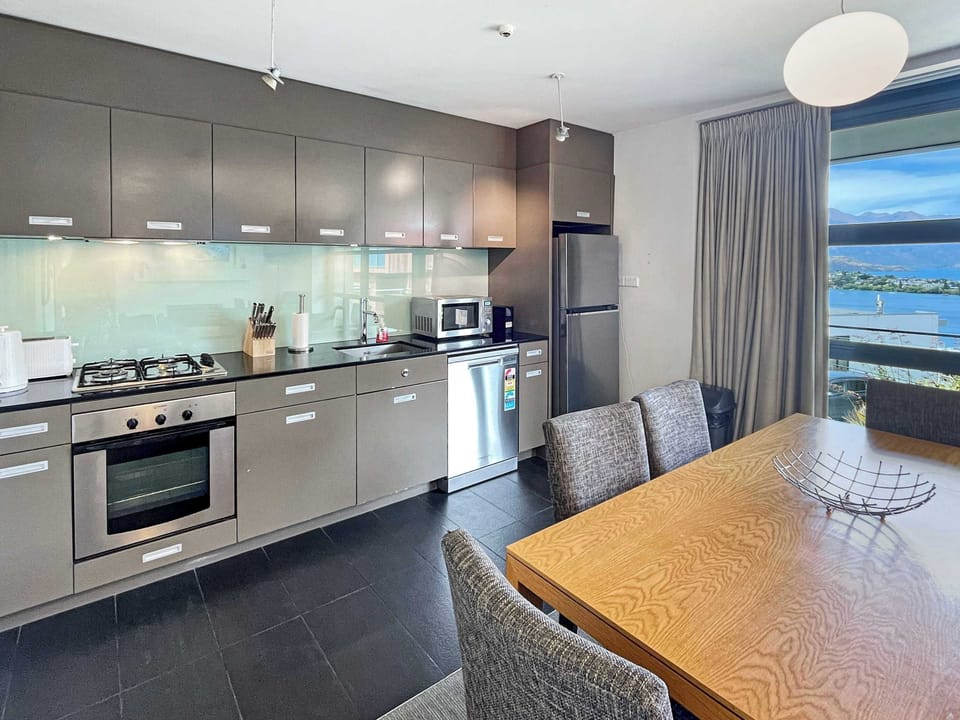 Modern, fully equipped kitchen and dining area with lake views, ideal for relaxed meals and entertaining during your stay.