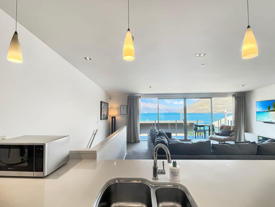 Kitchen island looking through to the living area and balcony with lake views beyond