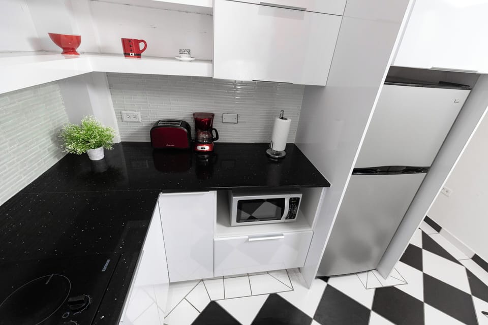 The corner sink offers a practical and efficient use of space, while the checkered floor tiles add a touch of classic charm.